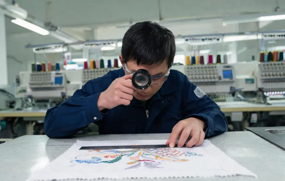 Application technician measuring an embroidered sample