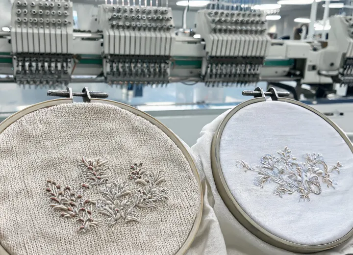Apparel embroidery on knit and woven garment panels